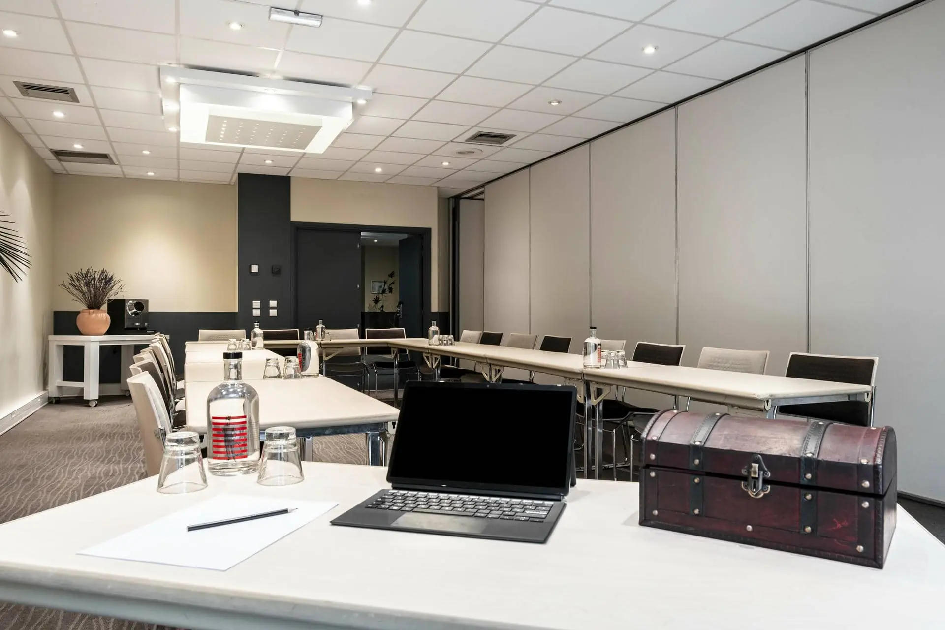 une salle de conférence avec un ordinateur portable et un coffre au trésor sur la table