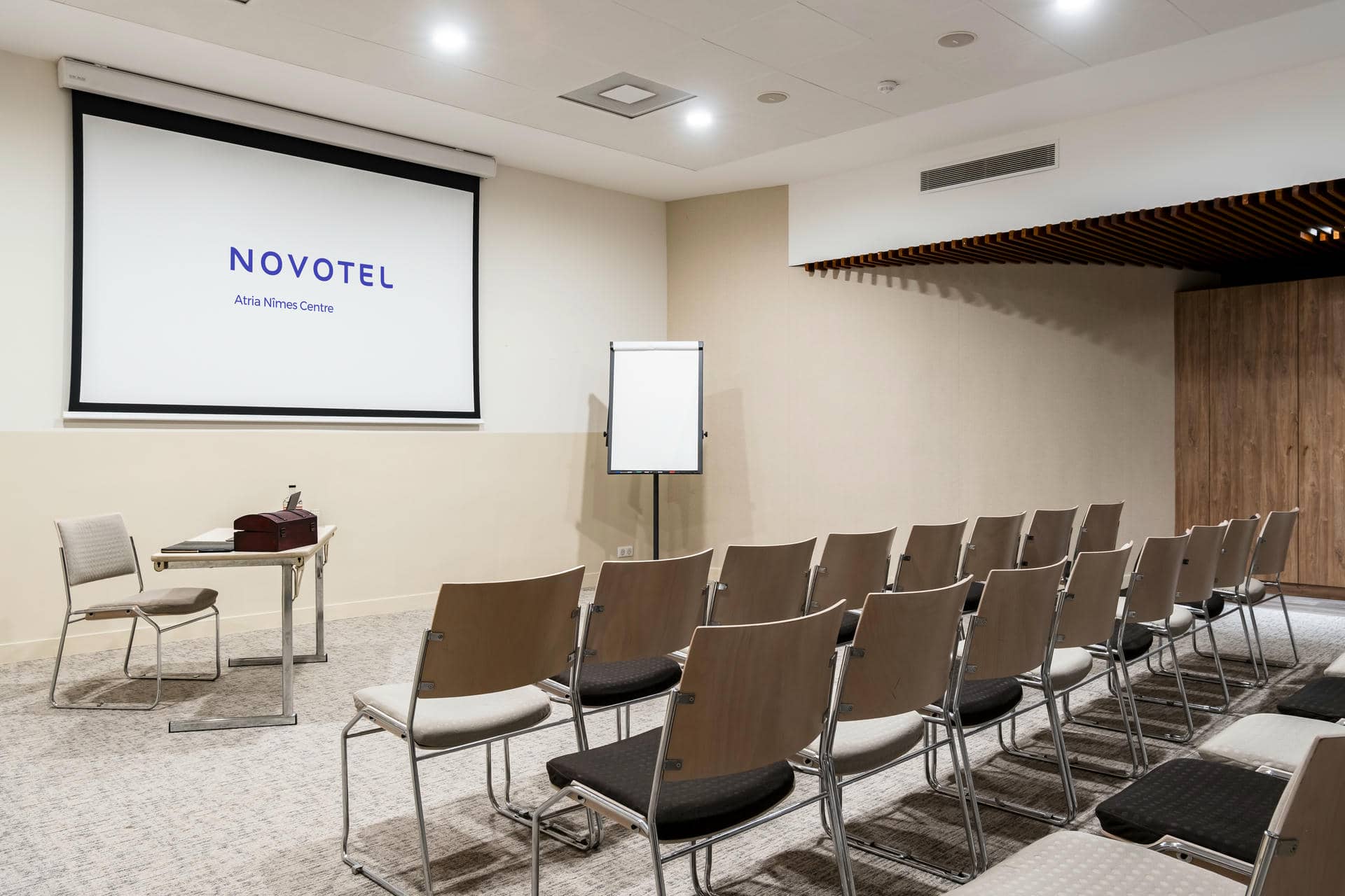 des rangées de chaises devant un écran de projection sur lequel est inscrit novotel