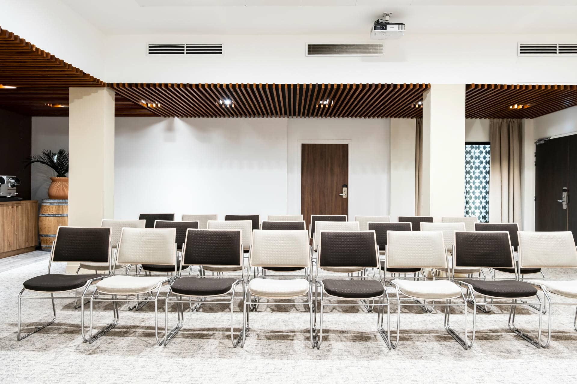 des rangées de chaises dans une salle avec un projecteur au plafond