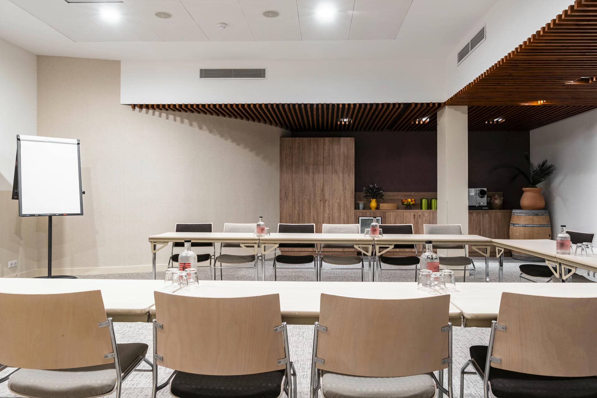 une salle de conférence avec des tables et des chaises et un tableau blanc