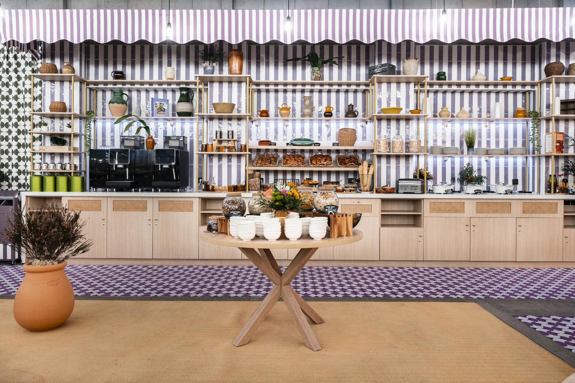 une cuisine avec un mur rayé violet et blanc et une table