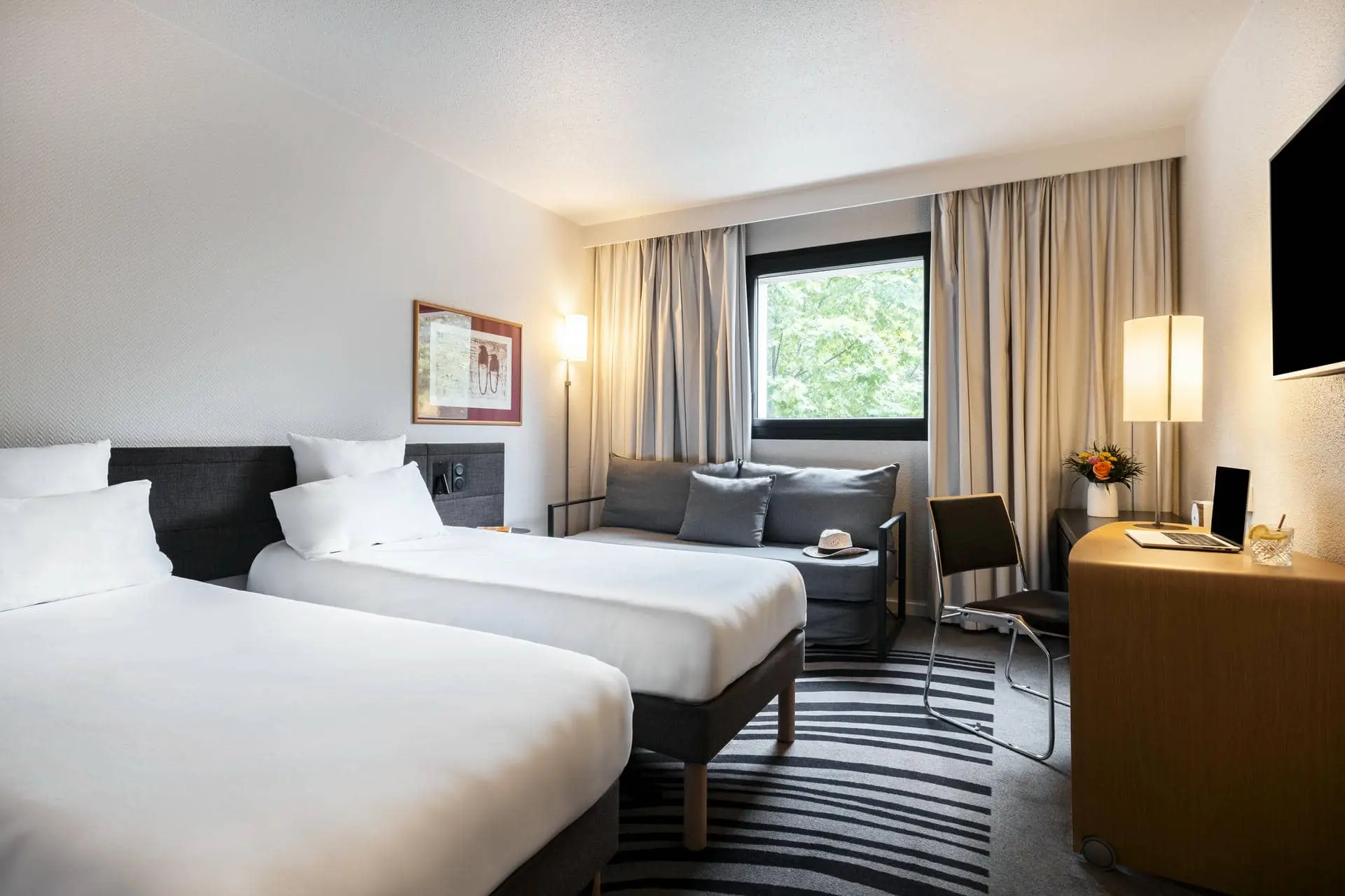 une chambre d'hôtel avec deux lits et un canapé