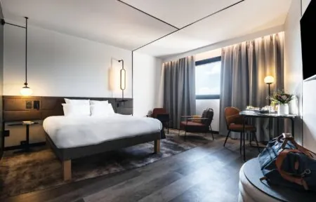 une chambre d'hôtel avec un grand lit et des chaises