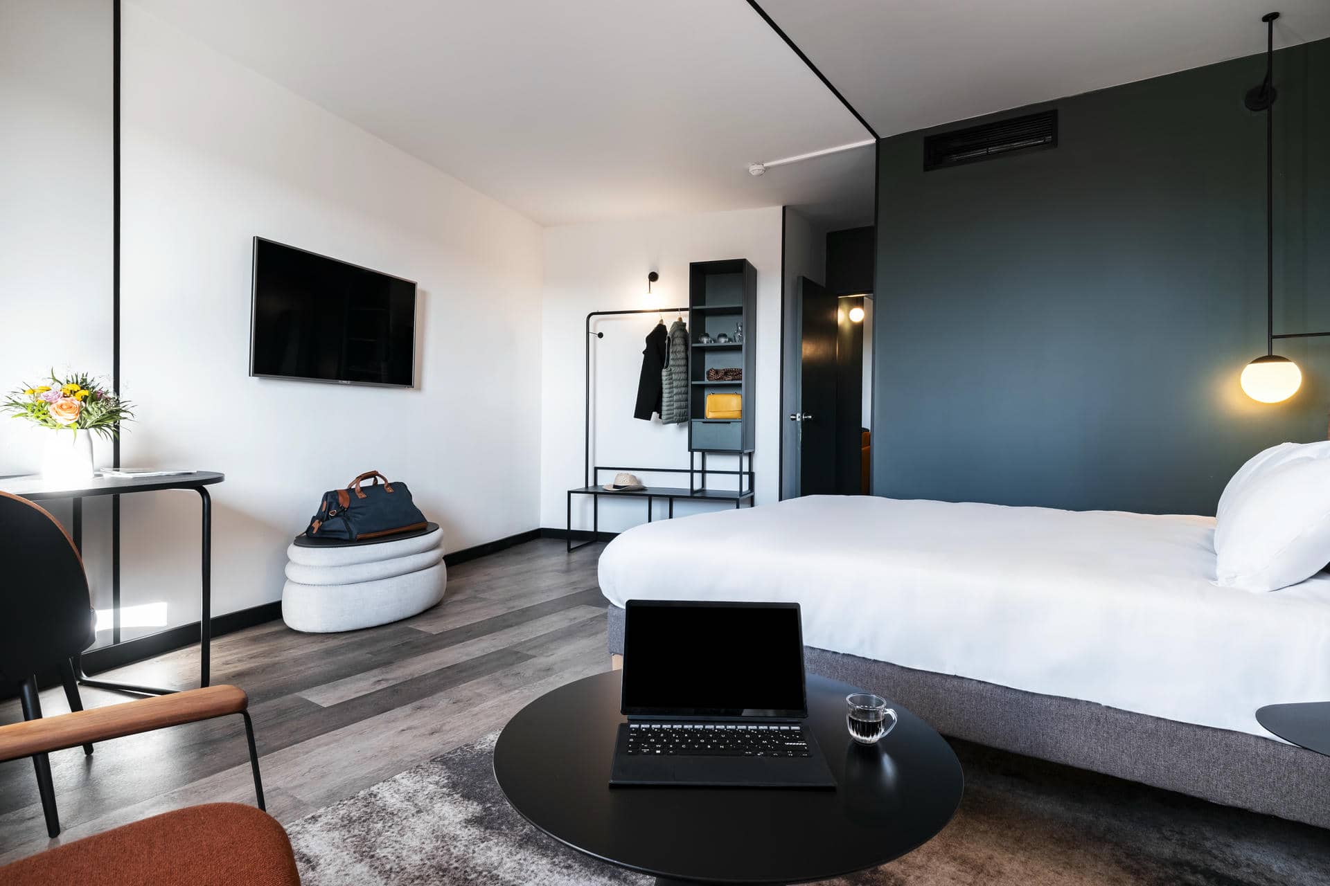 une chambre d'hôtel avec un lit et un ordinateur portable sur une table