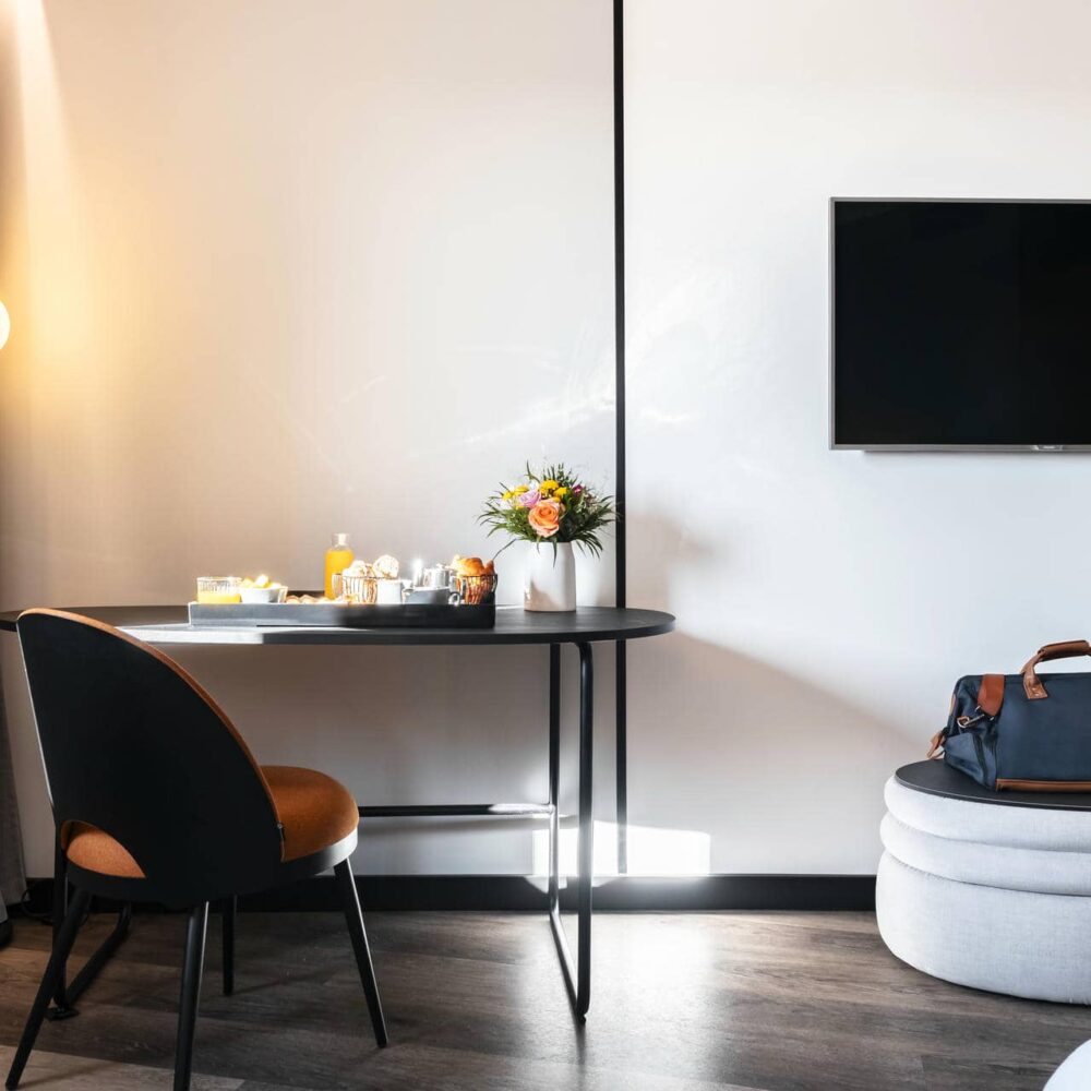 un téléviseur noir à écran plat est fixé au mur au-dessus d'un bureau