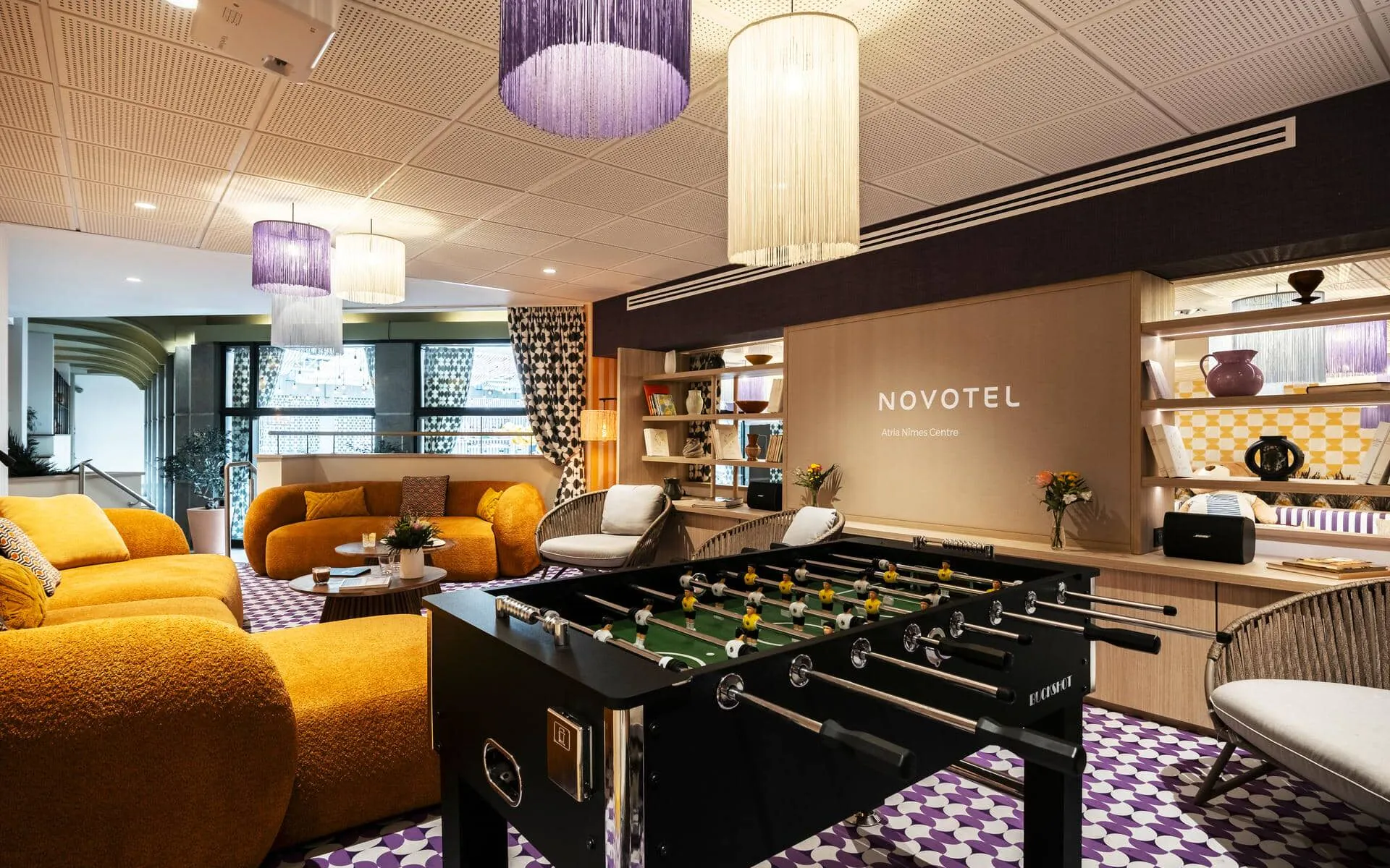 une salle avec un baby-foot et un panneau indiquant novotel