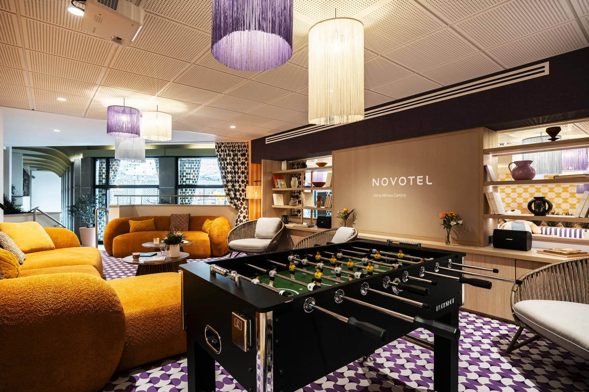 une salle avec un baby-foot et un panneau indiquant novotel