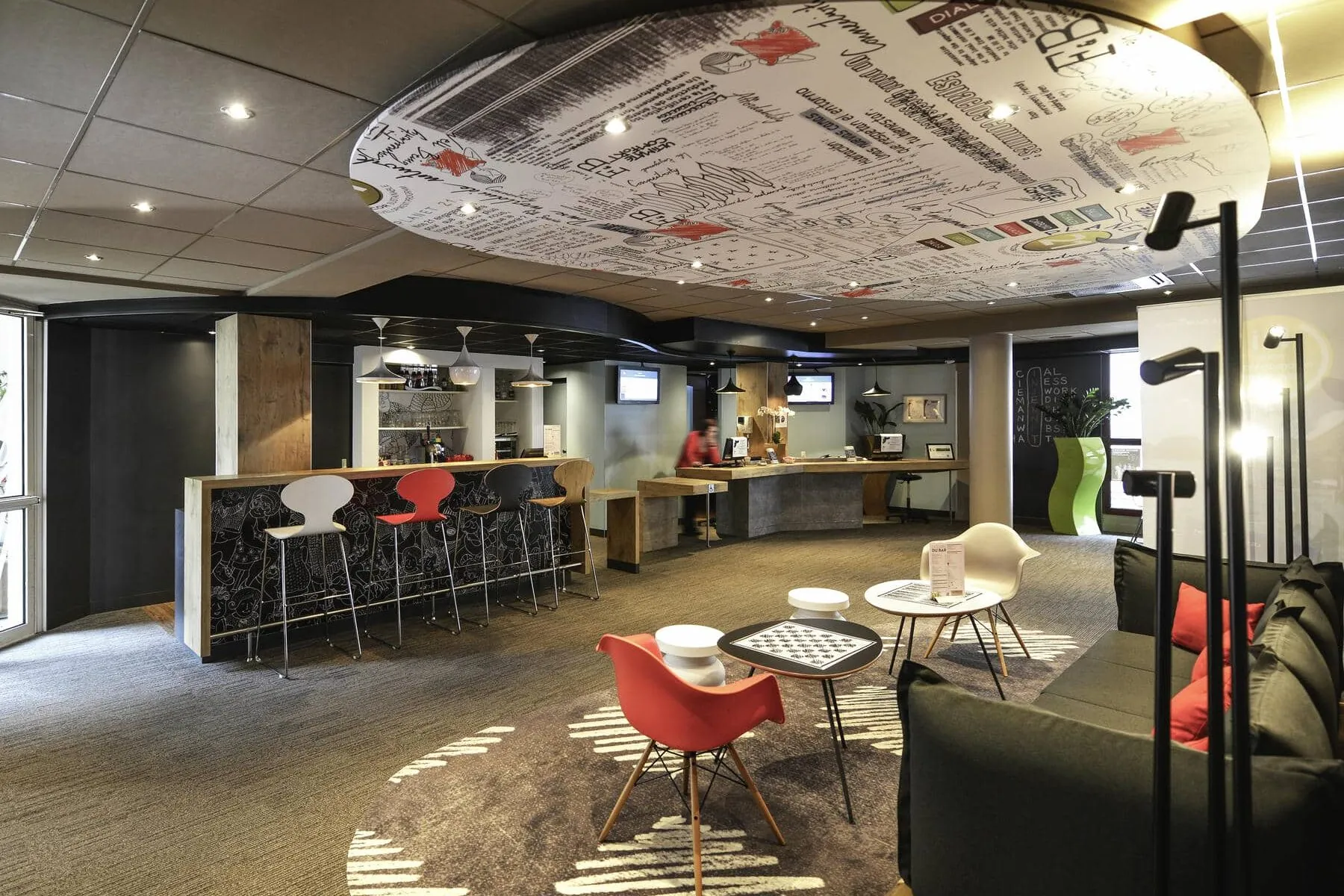 a hotel lobby with a ceiling that says ibis on it