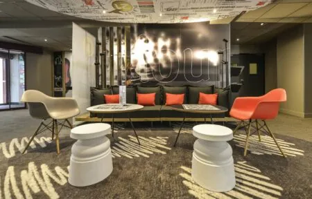 a room with a couch and chairs and a sign that says ibis