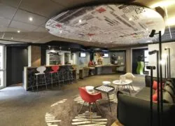 a hotel lobby with a ceiling that says ibis on it