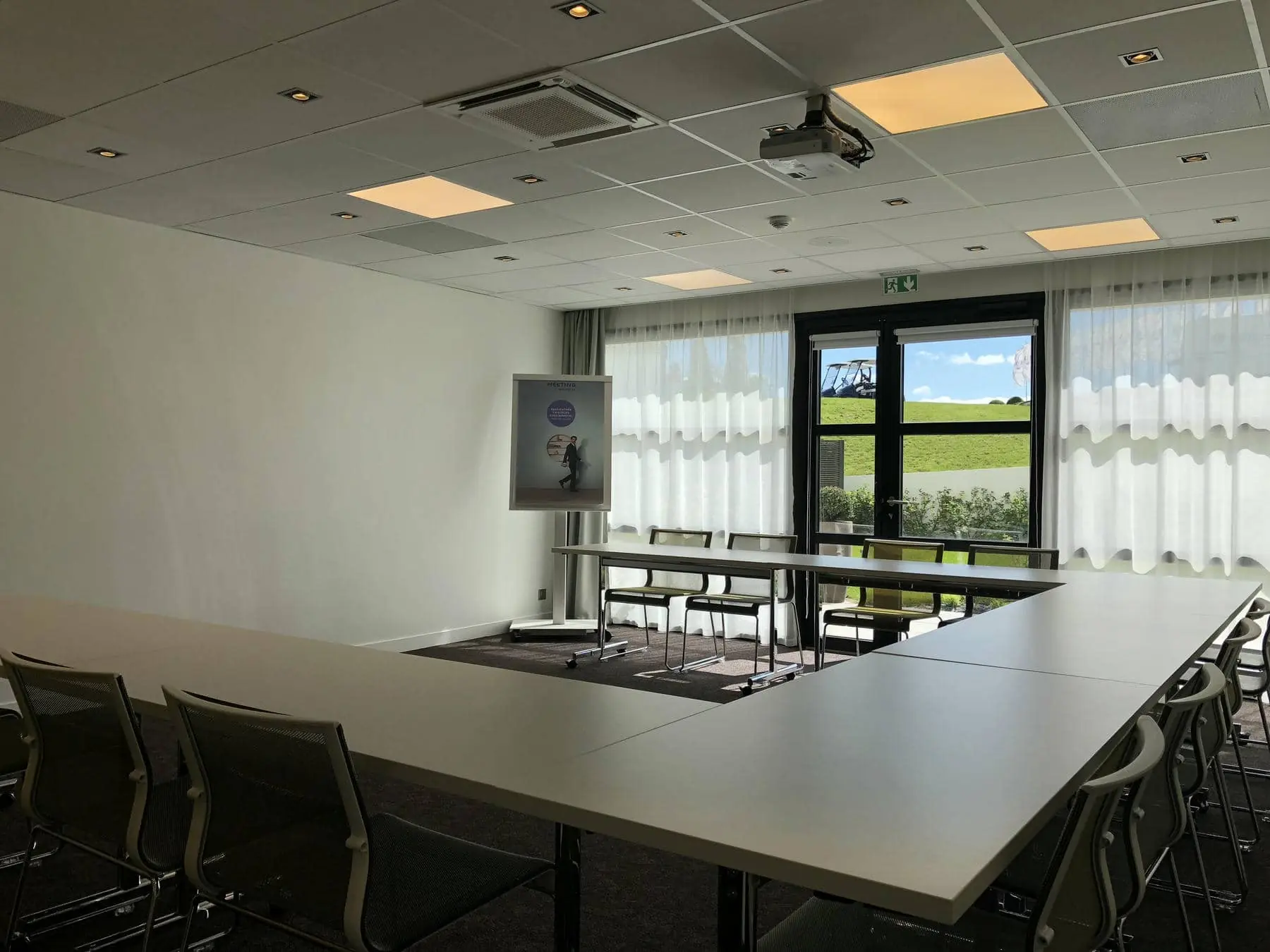 a conference room with tables and chairs and a projector