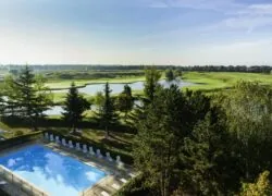 une vue aérienne d'une piscine avec un terrain de golf en arrière-plan