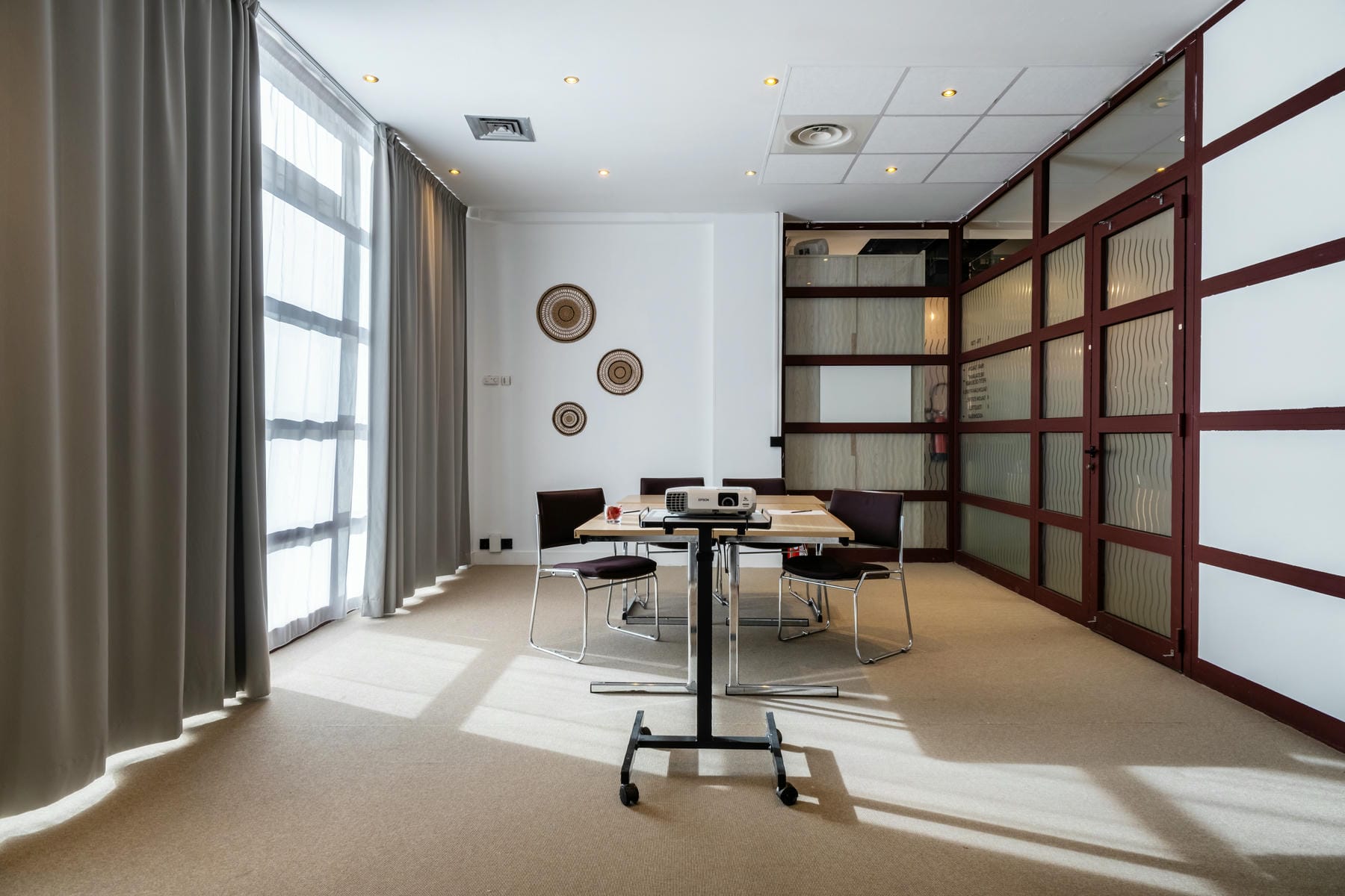 une salle de conférence avec une table, des chaises et un projecteur