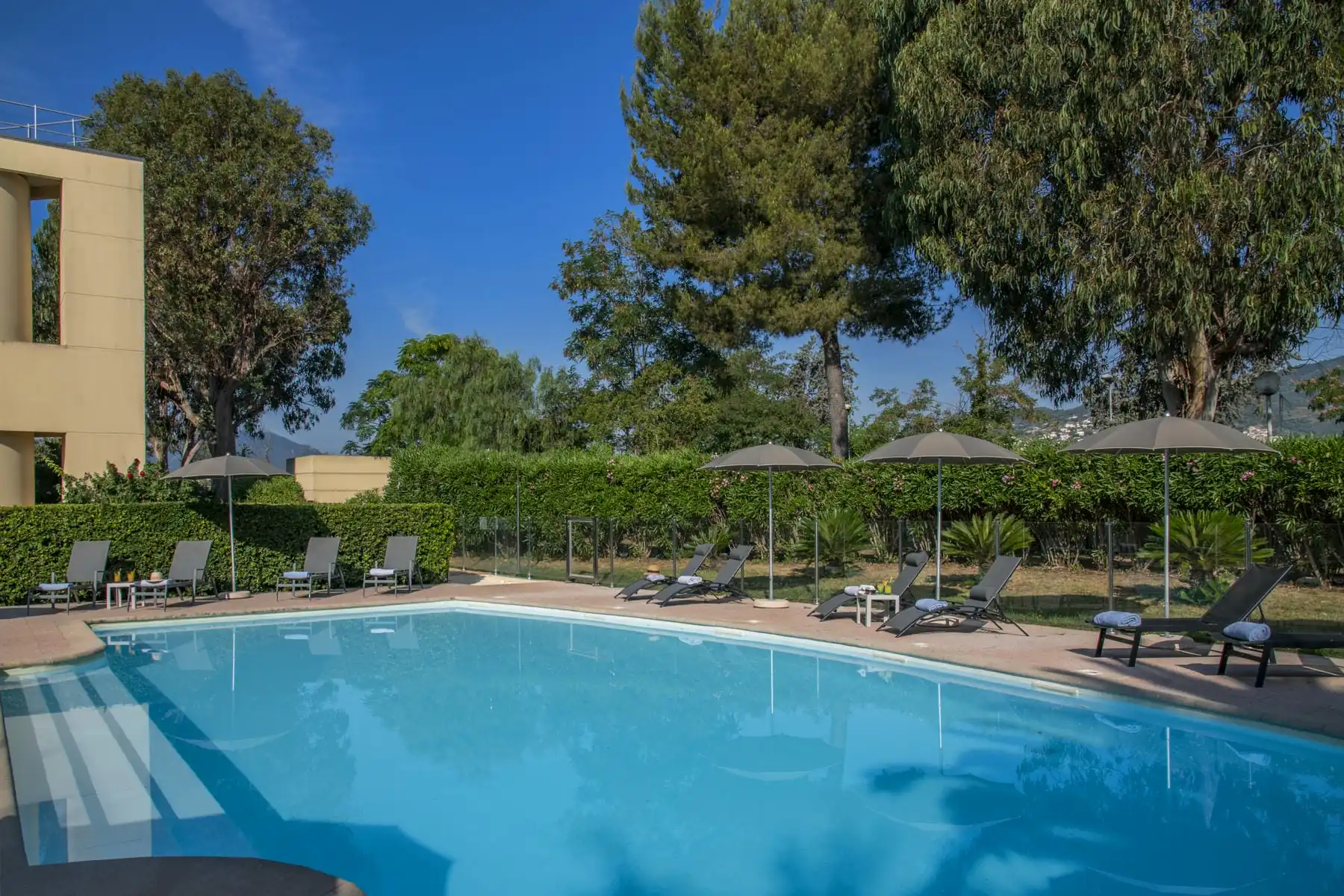 une grande piscine entourée de chaises et de parasols