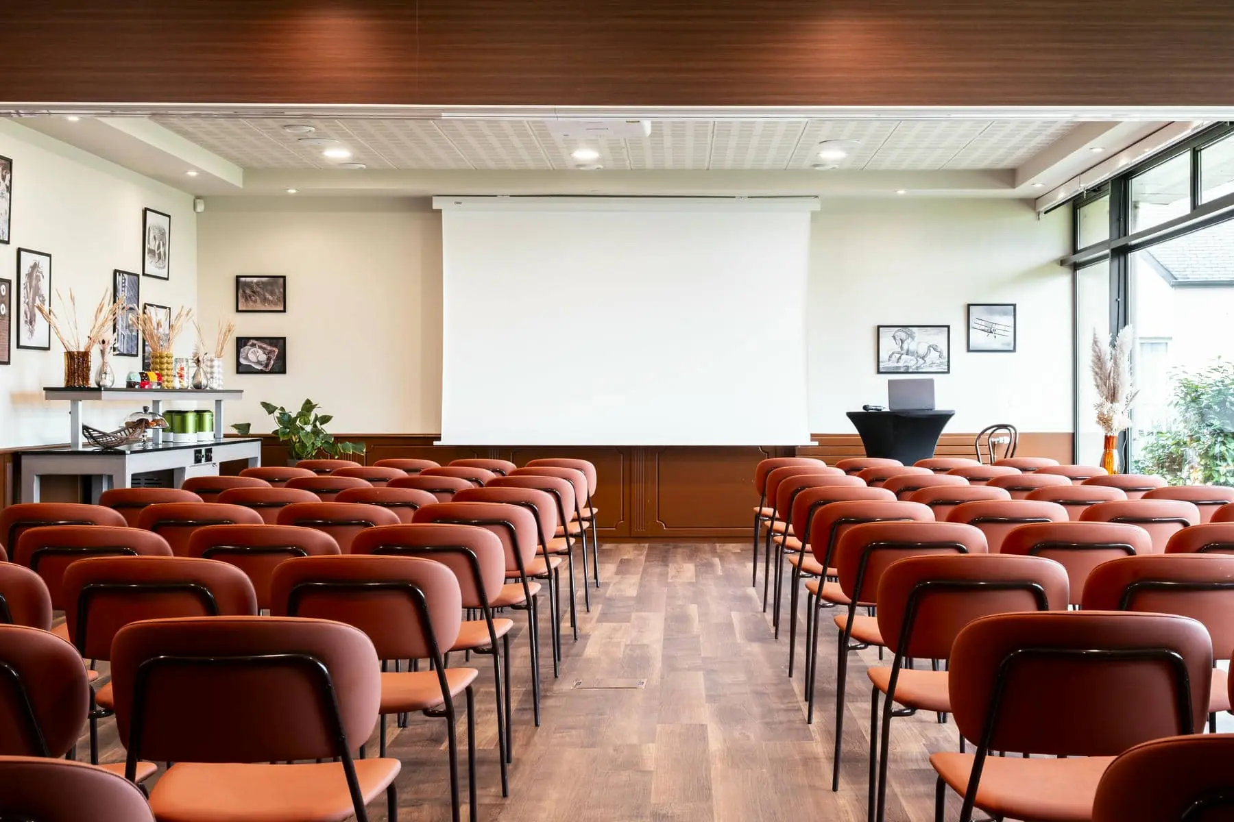 des rangées de chaises rouges devant un écran de projection