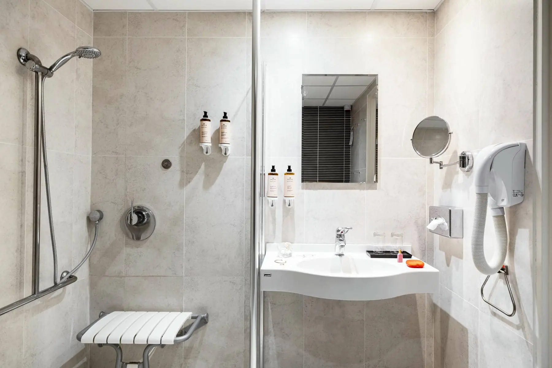 une salle de bain avec un lavabo, un miroir et une douche