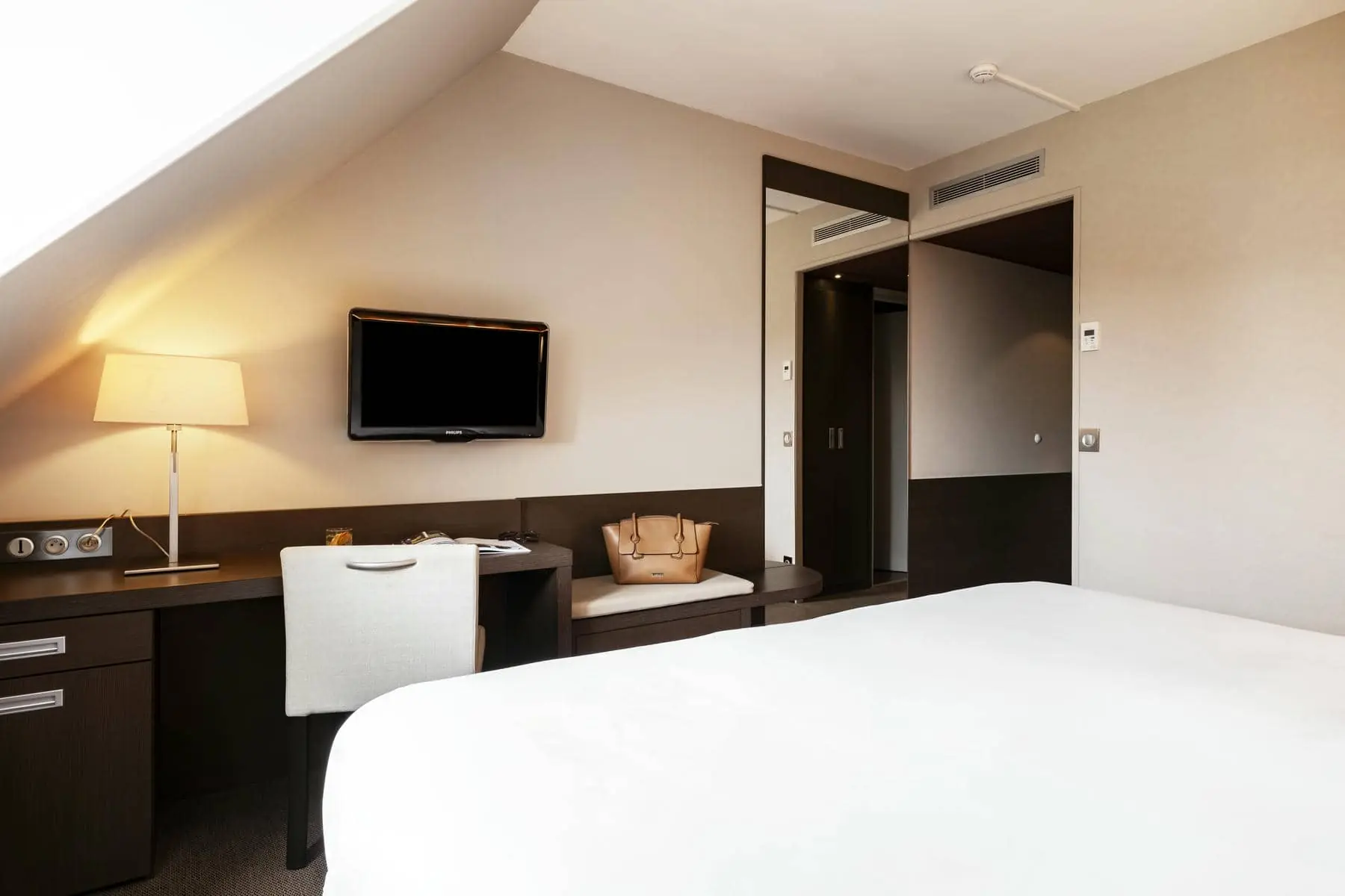 une chambre d'hôtel avec un bureau et une télévision à écran plat