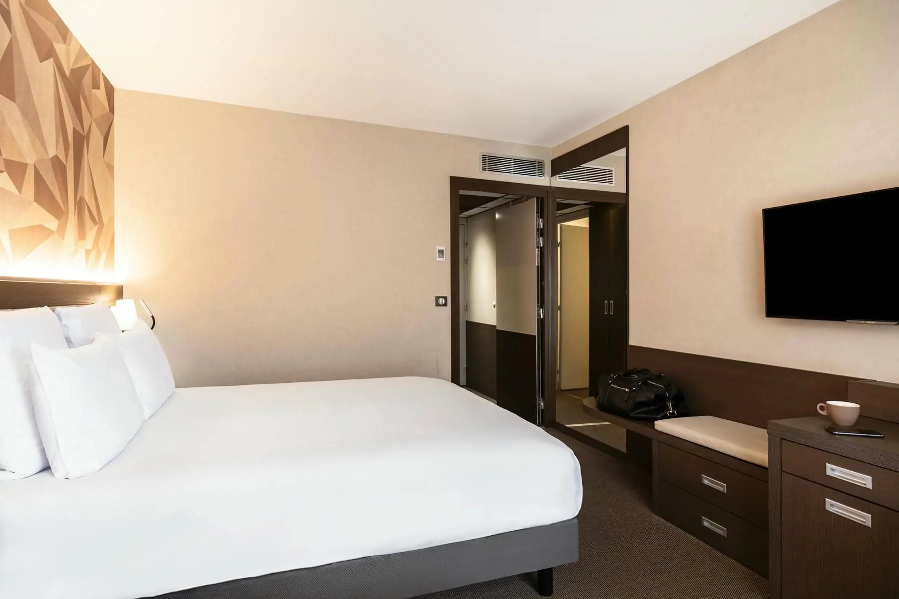 une chambre d'hôtel avec un grand lit et une télévision à écran plat