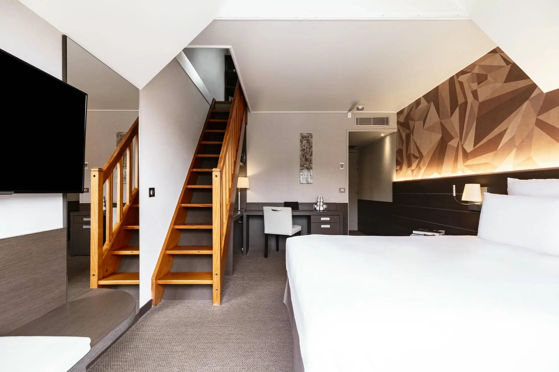 une chambre d'hôtel avec un escalier menant au deuxième étage
