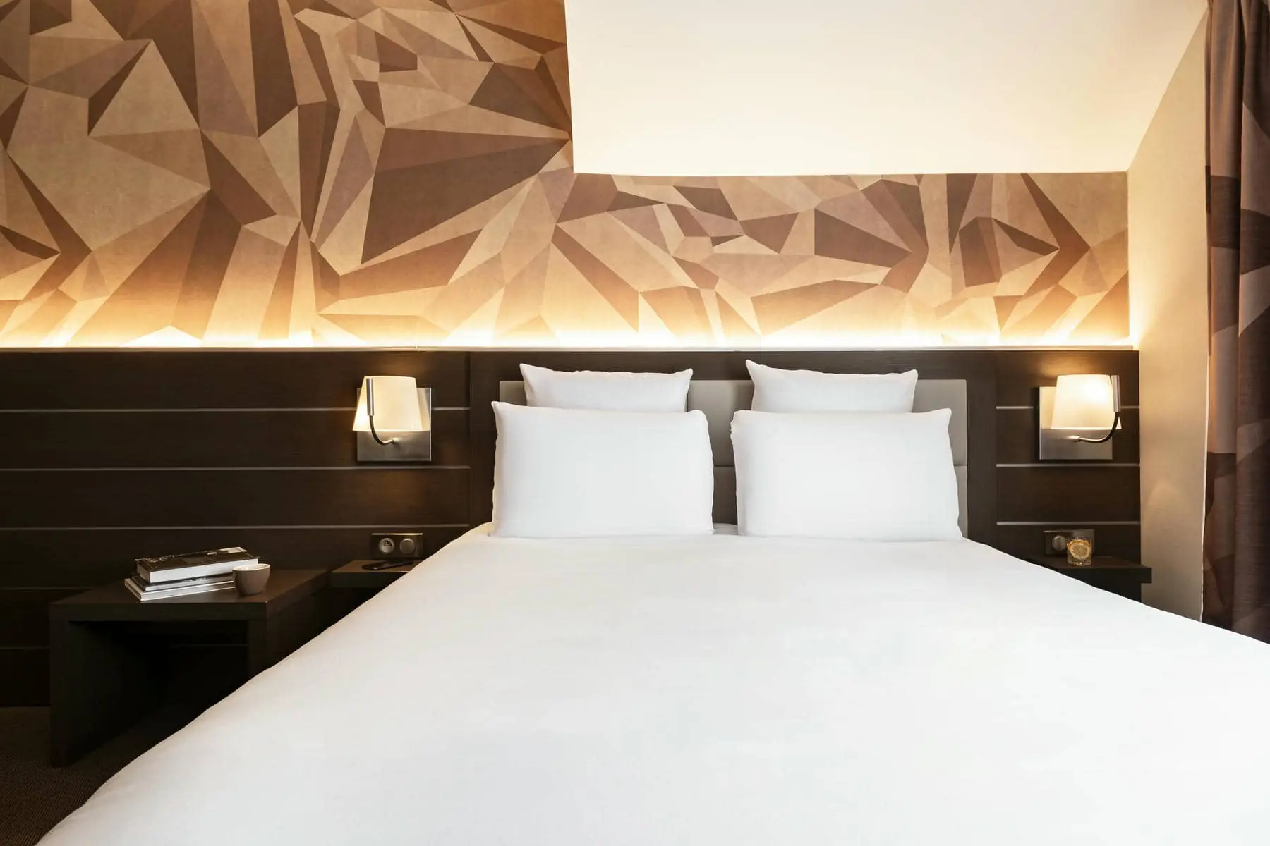 un lit avec des draps et des oreillers blancs dans une chambre d'hôtel