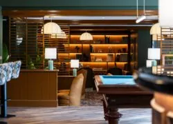 une pièce avec une table de billard et une étagère avec des livres dessus