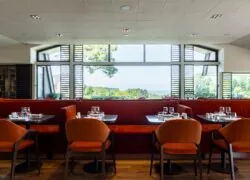 un restaurant avec des tables et des chaises et une grande fenêtre