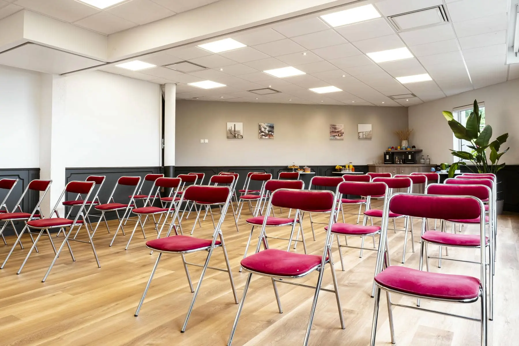 des rangées de chaises pliantes rouges dans une salle de conférence