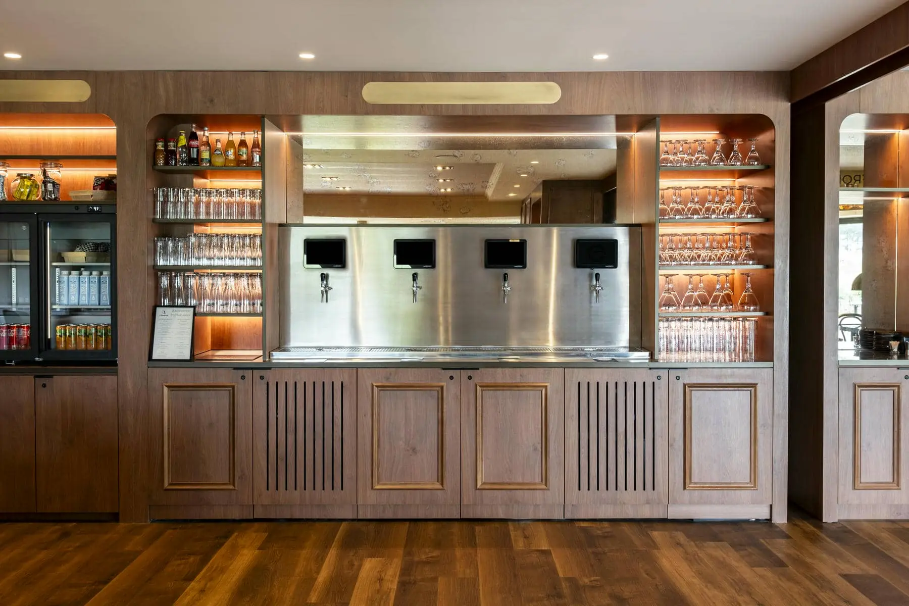 un bar avec des appareils en acier inoxydable et des armoires en bois