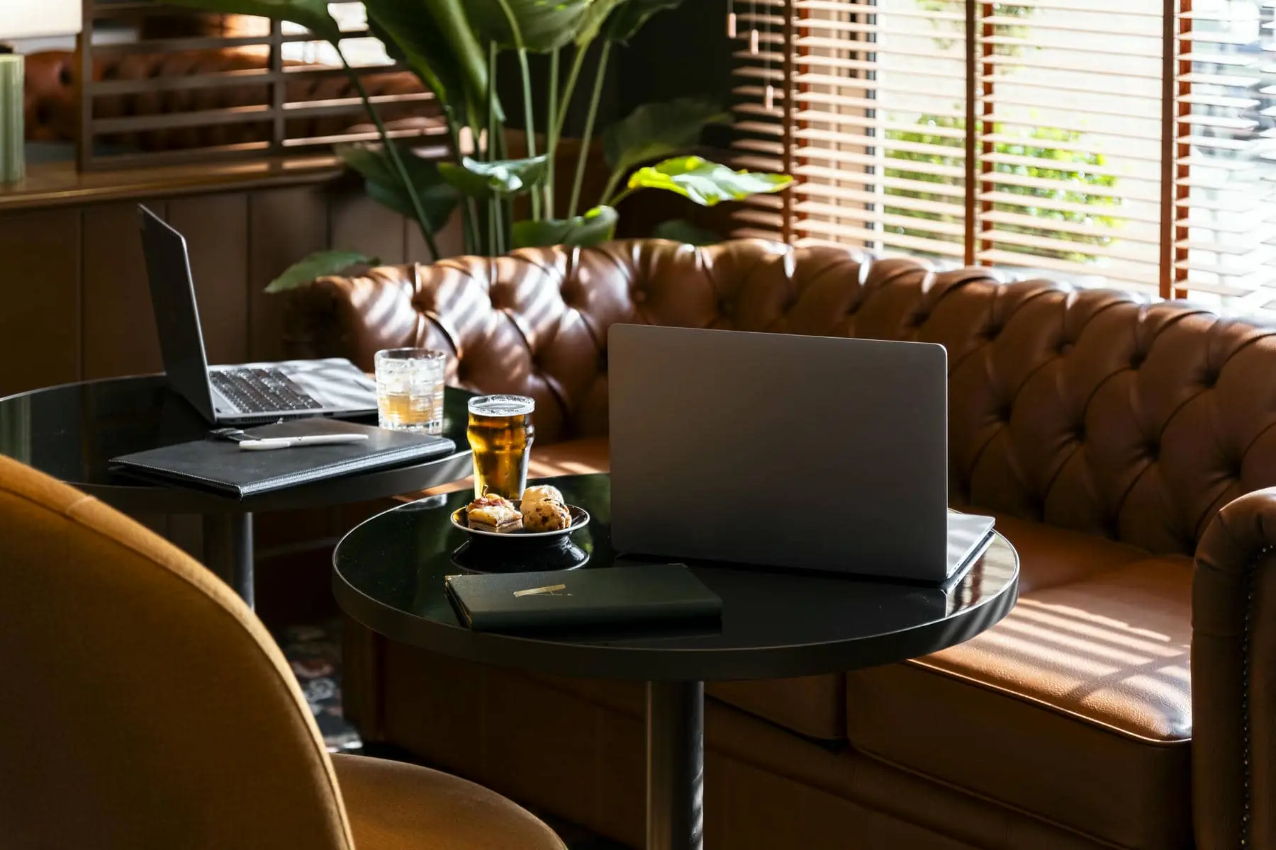 un canapé avec un ordinateur portable et un verre de bière dessus