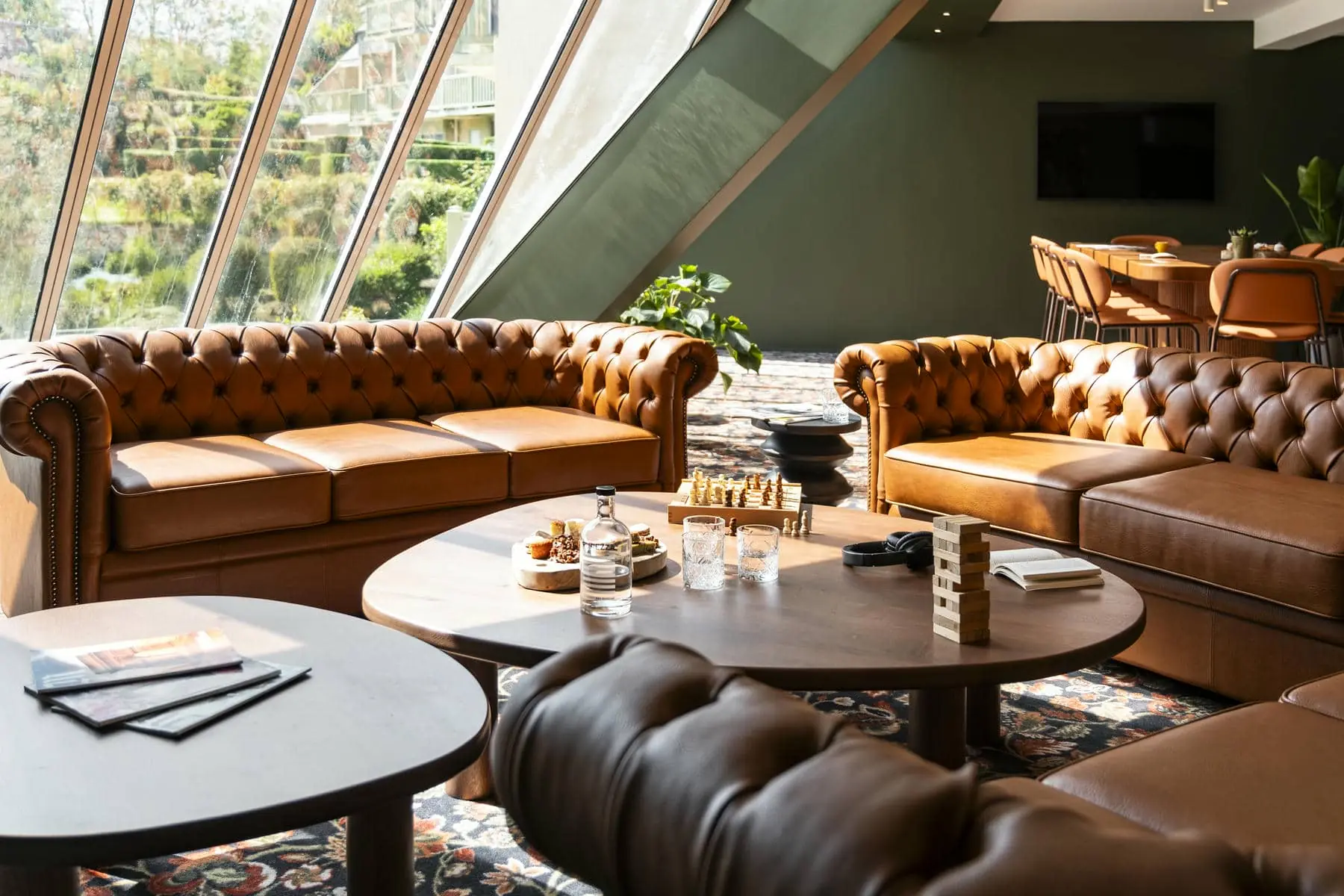 un salon avec des canapés en cuir marron et une table sur laquelle se trouve un jeu de jenga