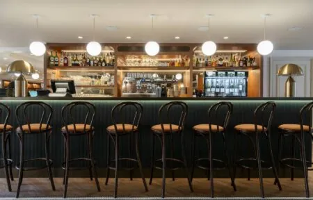 a row of bar stools are lined up in front of a bar