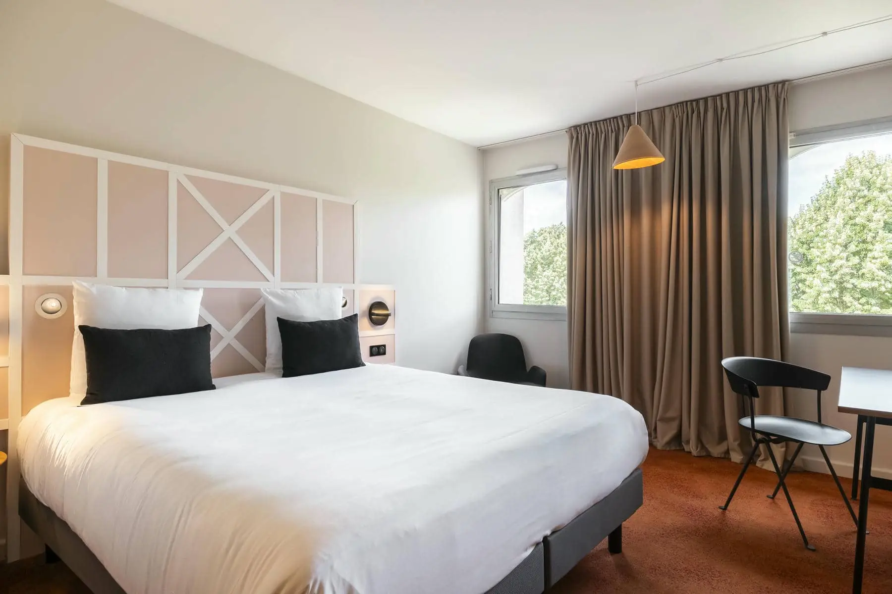 a hotel room with a large bed and a chair