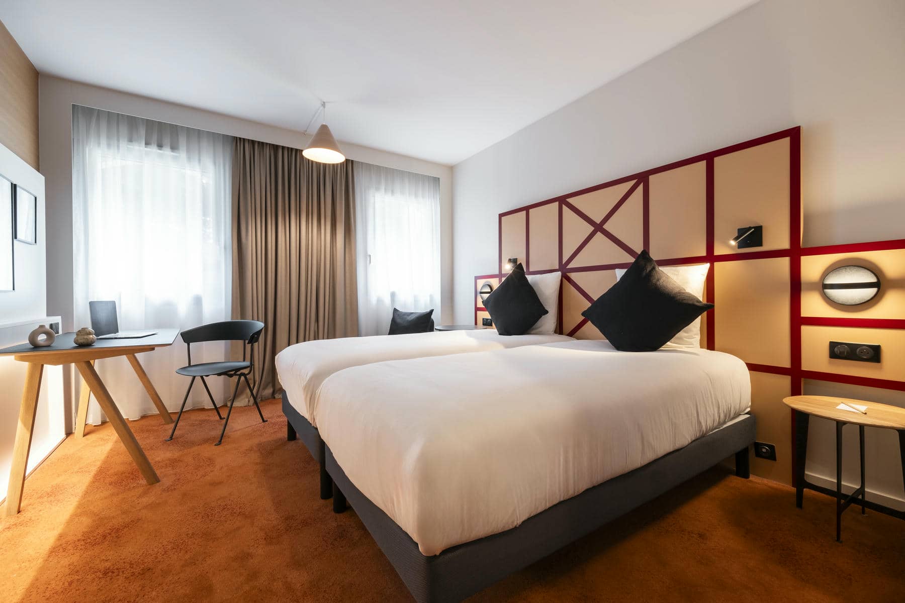 une chambre d'hôtel avec deux lits et un bureau