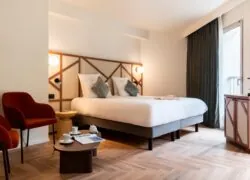 une chambre d'hôtel avec un lit et deux chaises