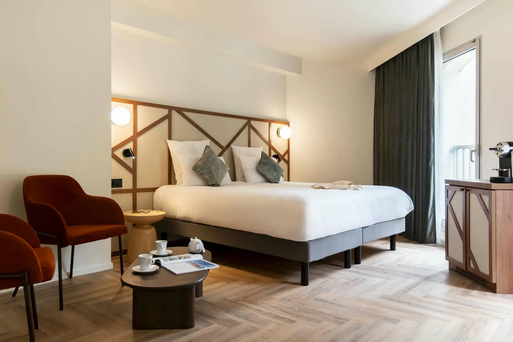 a hotel room with a large bed and two chairs