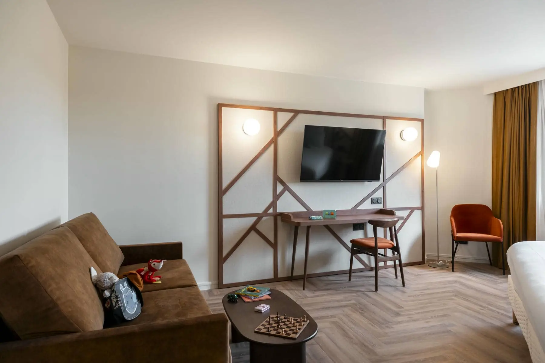 a living room with a couch a desk and a flat screen tv