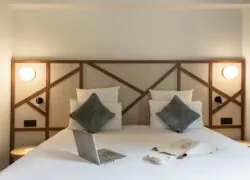 un lit avec des oreillers et un ordinateur portable dessus