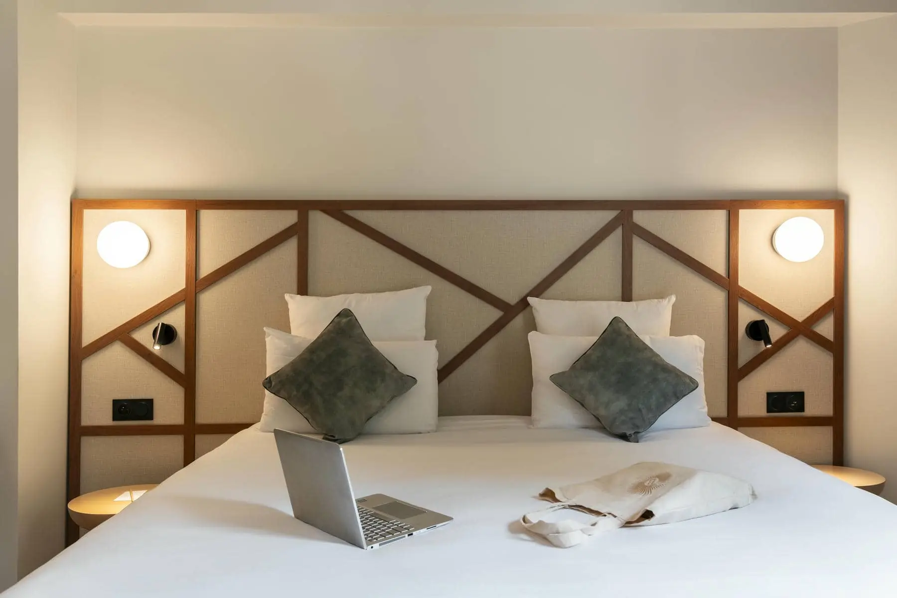 a bed with pillows and a laptop on it