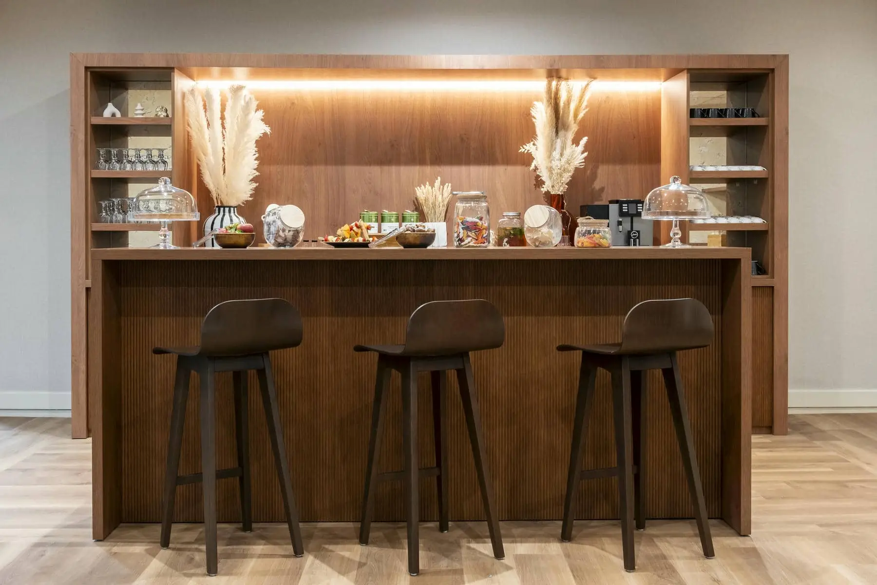 a wooden bar with three stools in front of it