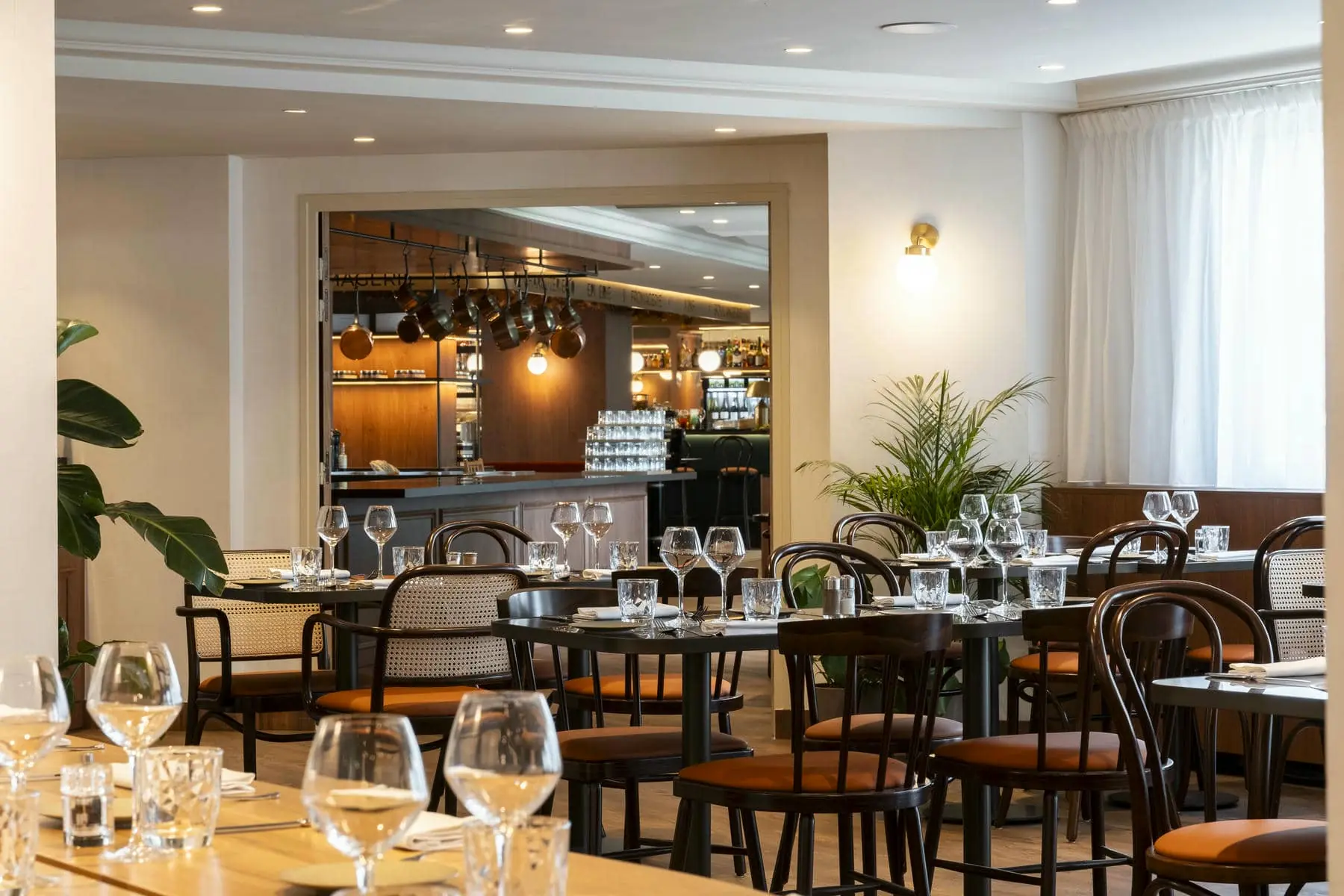 a restaurant filled with tables and chairs and glasses of wine