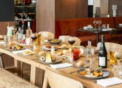 une table avec des assiettes de nourriture et une bouteille de vin