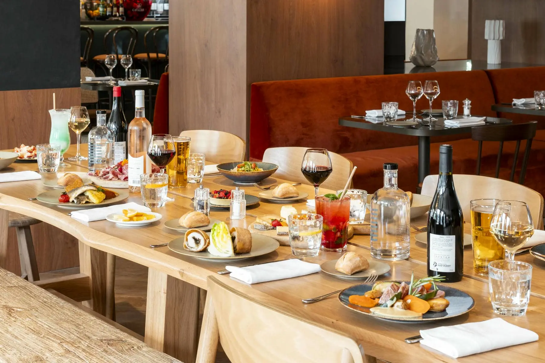 a table with plates of food and a bottle of wine