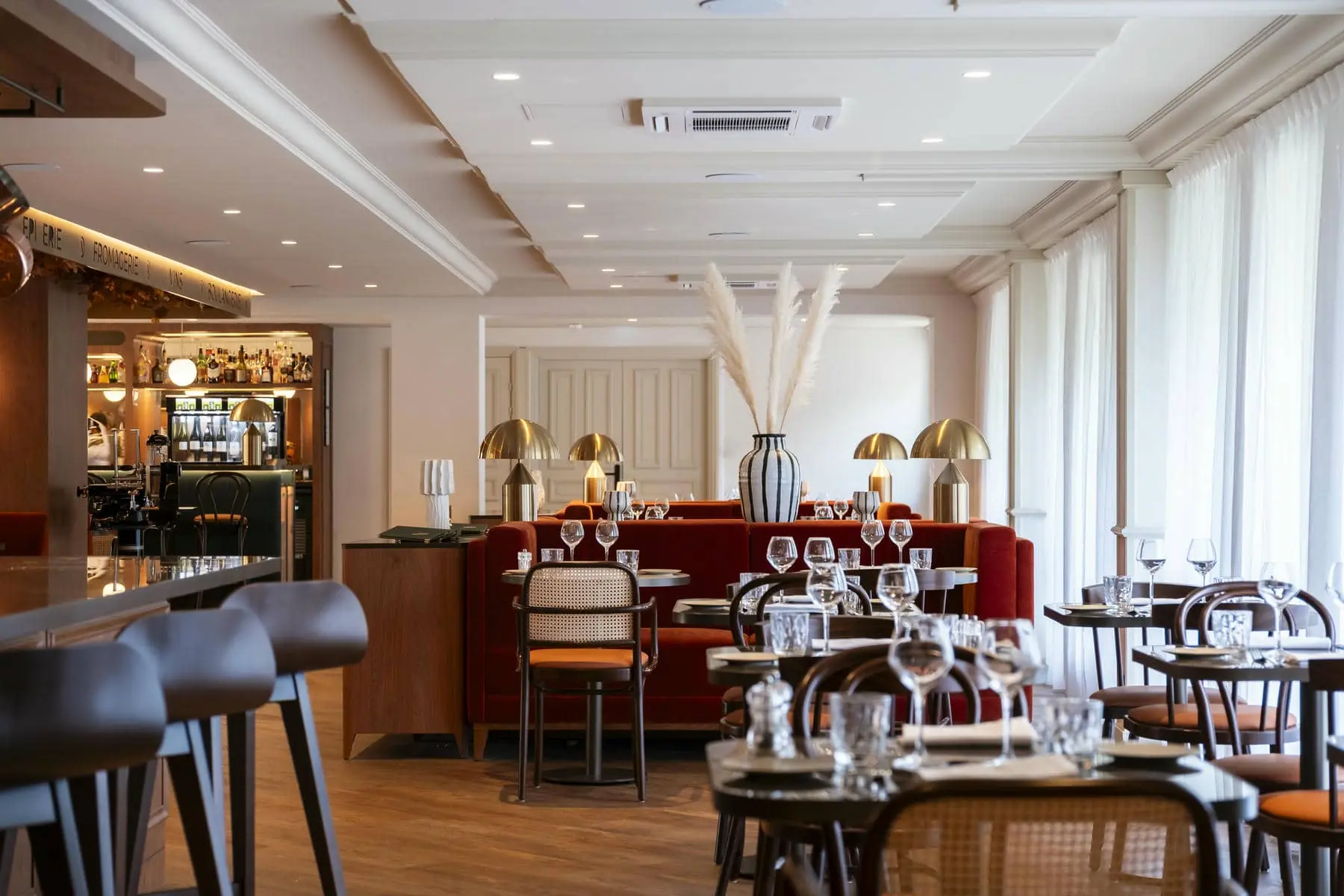 a restaurant with tables and chairs and a sign on the wall that says ' l' ancienne '