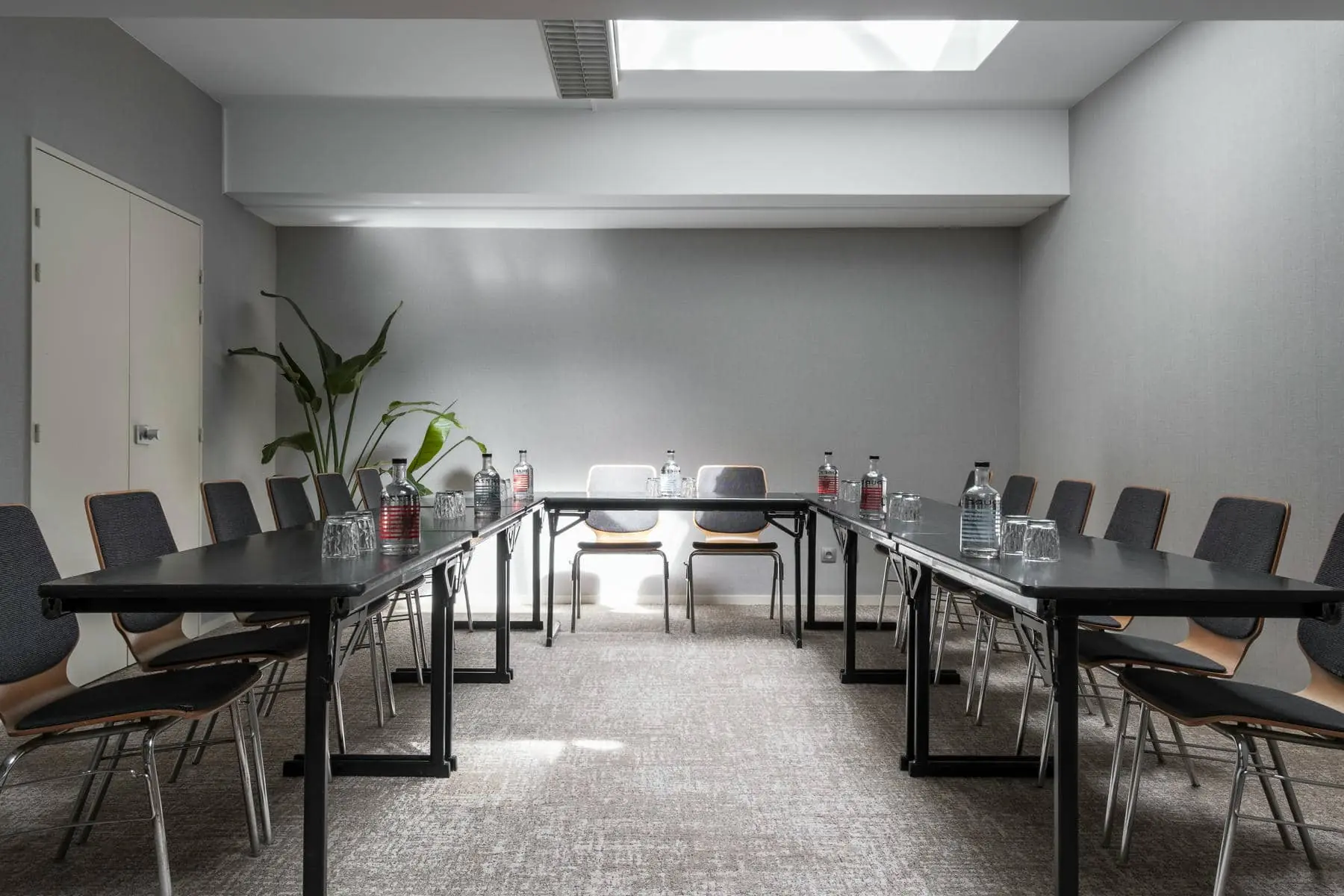 a conference room with tables and chairs and bottles of water