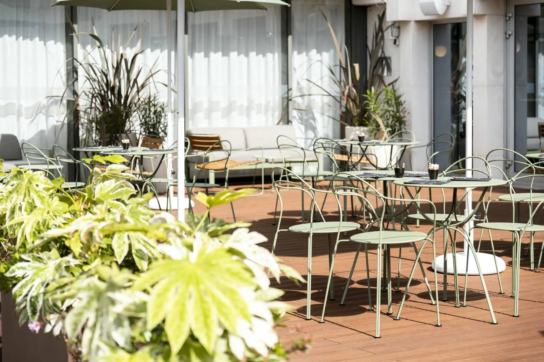 a patio with tables and chairs and an umbrella