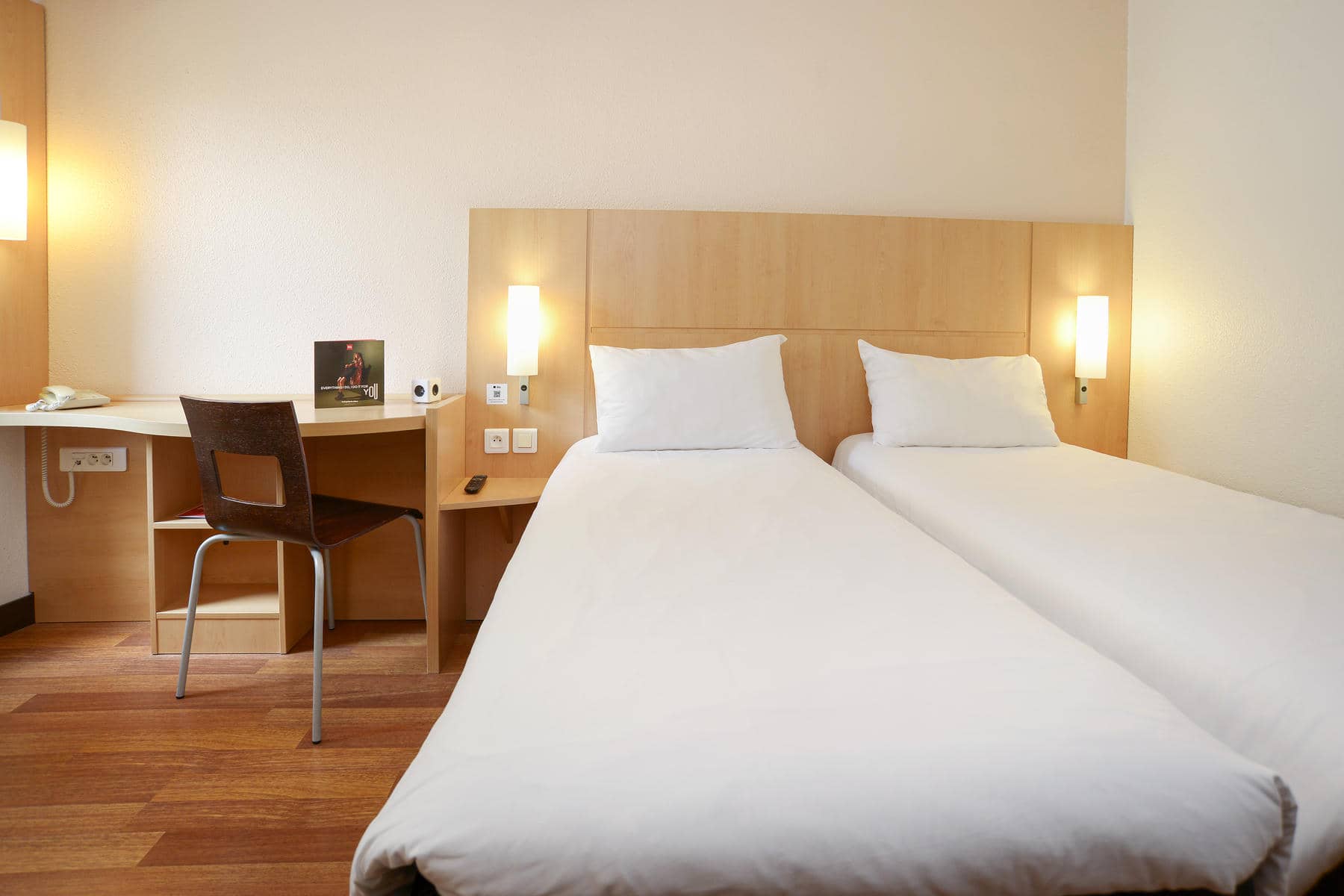 une chambre d'hôtel avec deux lits et un bureau