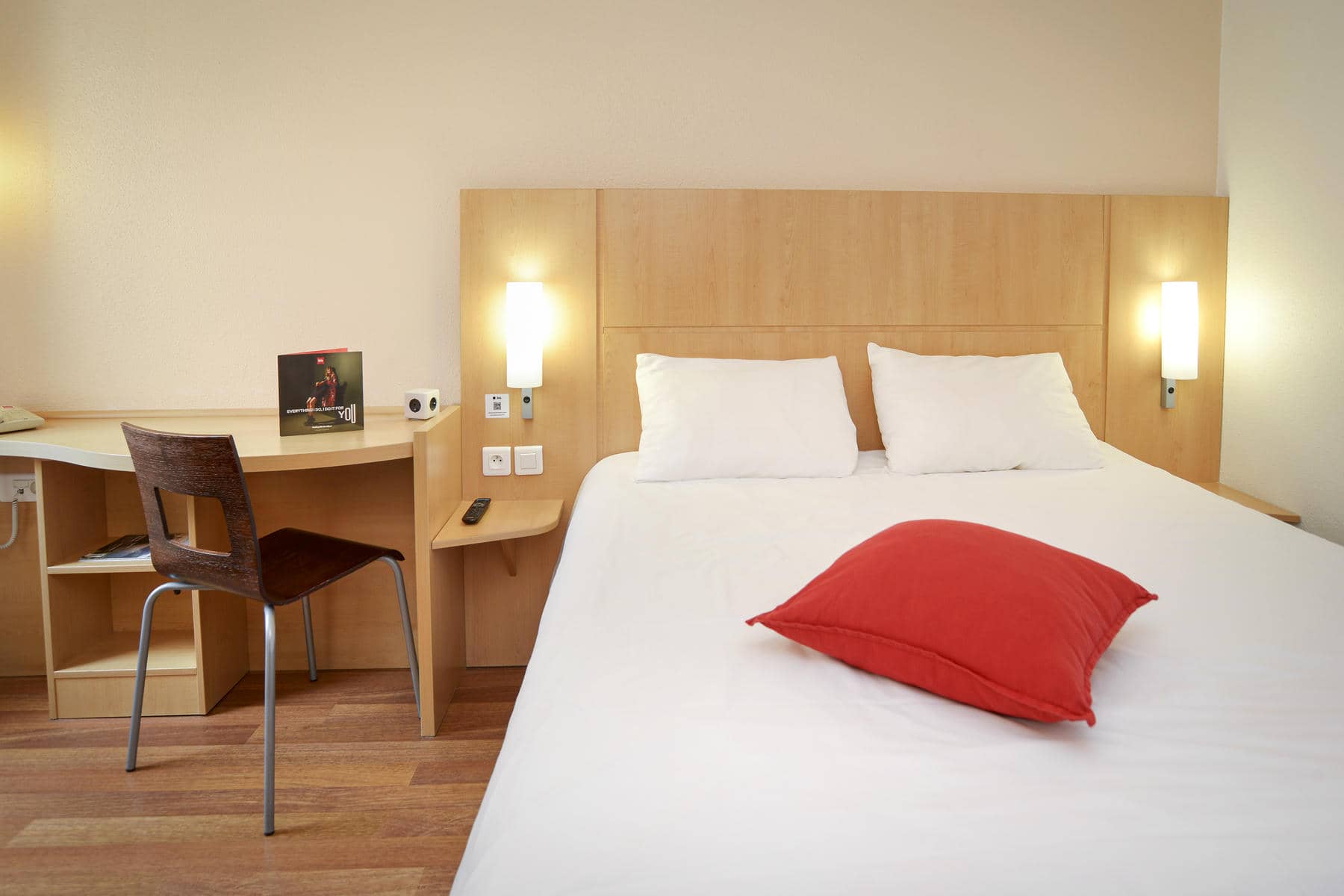 une chambre d'hôtel avec un oreiller rouge sur le lit