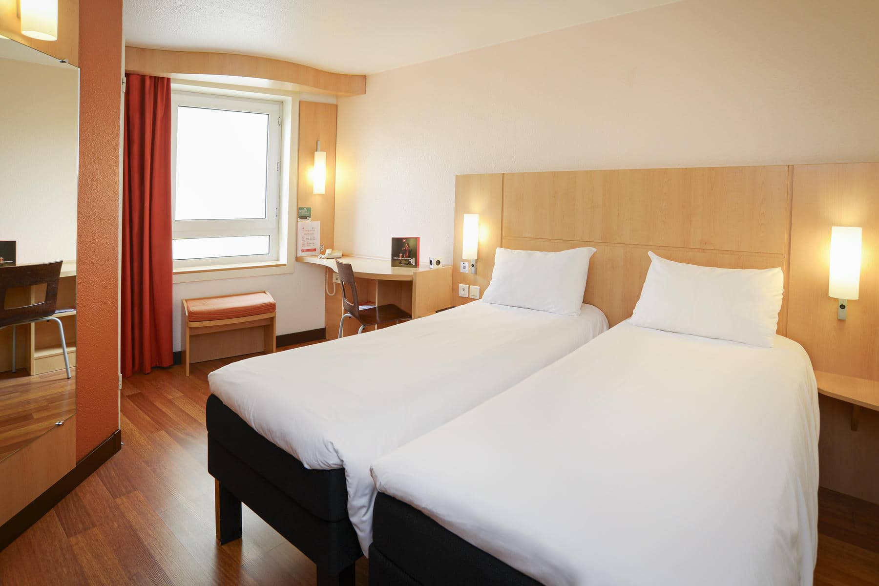 une chambre d'hôtel avec deux lits et un bureau