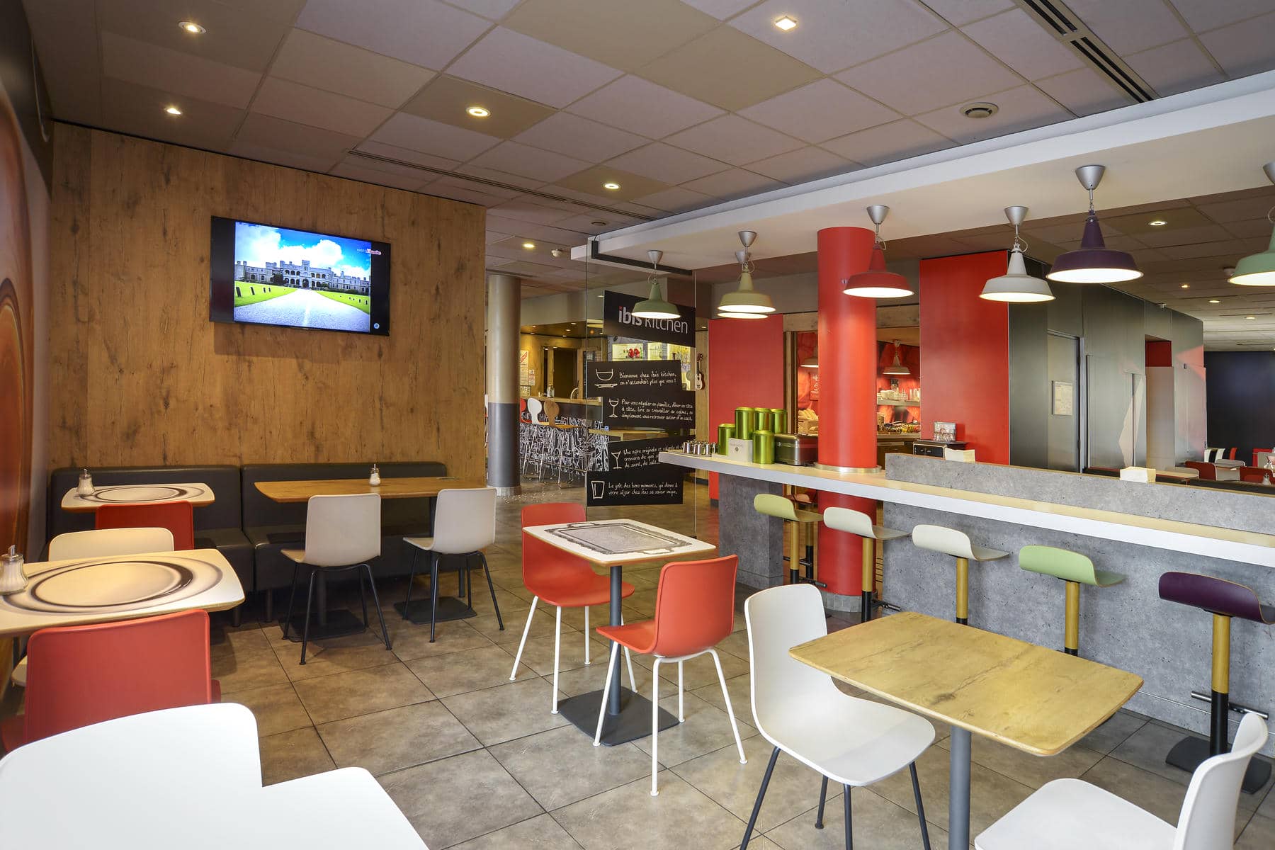 un restaurant avec des tables et des chaises et un panneau indiquant ibis hotels