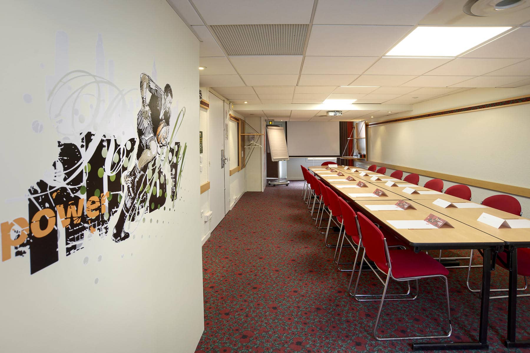 une salle de conférence dont le mur est orné d'une peinture murale représentant le pouvoir